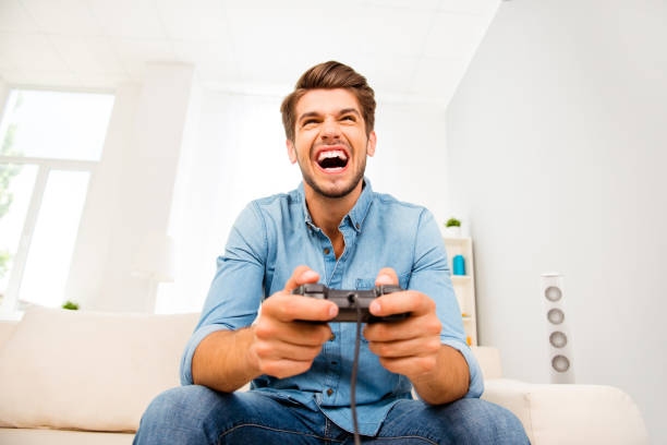istock Young happy man laughing and playing video games on weekend 638845718