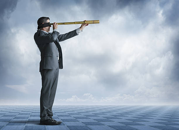 istock Blindfolded Businessman Standing On Large Chessboard Looks Forward Through Spyglass 638847274
