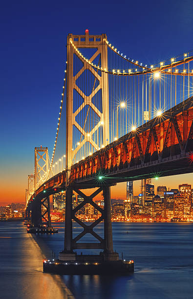 le pont bay bridge et san francisco, au coucher du soleil - san francisco oakland bay bridge photos et images de collection