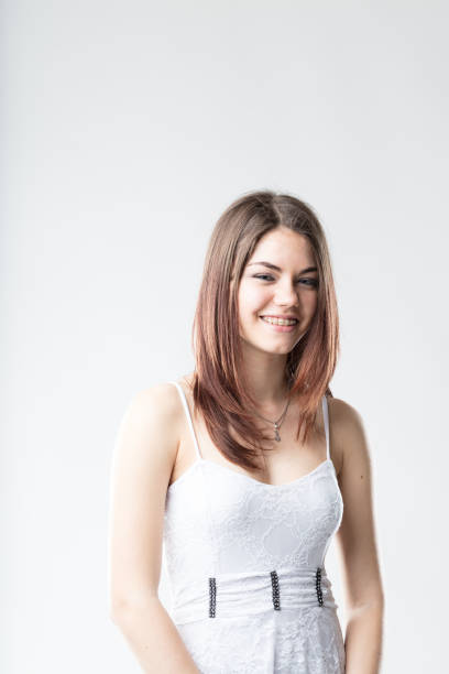 istock girl smiling in white dress 638857570