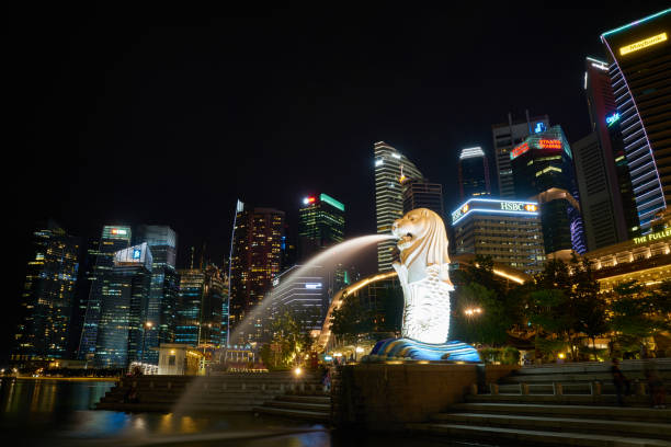 estatua de merlion y rascacielos en singapur - merlion singapore marina bay lighting equipment fotografías e imágenes de stock