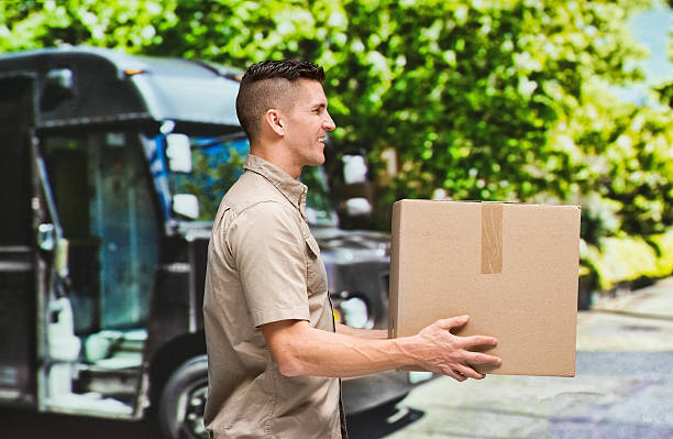 istock Smiling worker holding box outdoors 638859042
