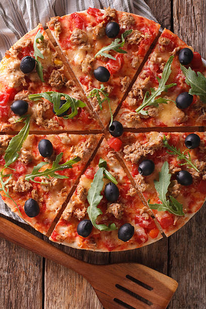 istock Italian pizza with tuna, olives and arugula close-up. Vertical 638861032