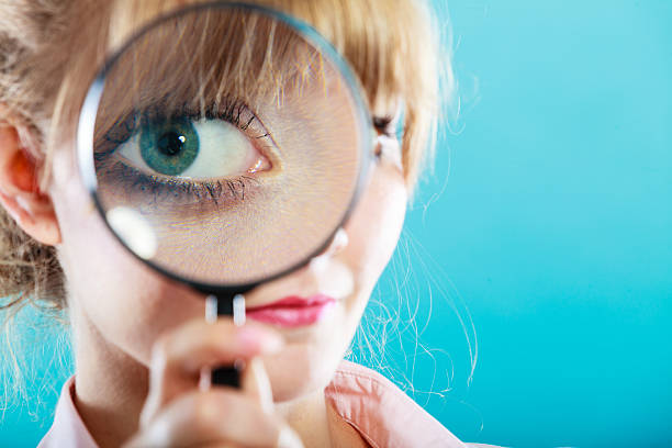 istock Woman hand holding magnifying glass on eye 638863556