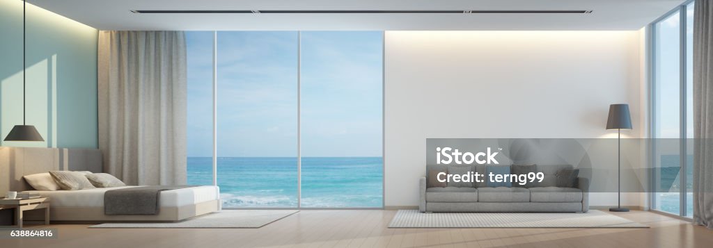 Dormitorio con vistas al mar y sala de estar en casa de playa de lujo - Foto de stock de Dormitorio - Habitación libre de derechos