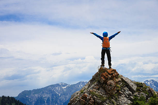 istock cheering successful woman backpacker open arms on mountain peak 638865318