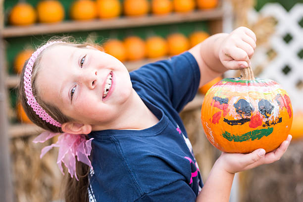 彼女の塗装されたカボチャを示す笑顔の小さな女の子 - pumpkin child little girls pumpkin patch ストックフォトと画像