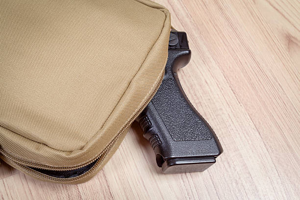 pistola arma in borsa, kaki o colore sabbia, sul tavolo - hiding carrying weapon handgun foto e immagini stock