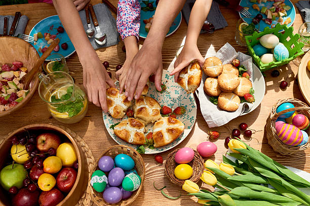 Spring dinner High angle view of family taking sweet buns when they having Easter dinner together easter cake photos stock pictures, royalty-free photos & images