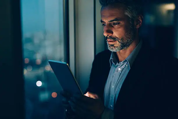 Photo of Buisnessman Using Tablet At Night