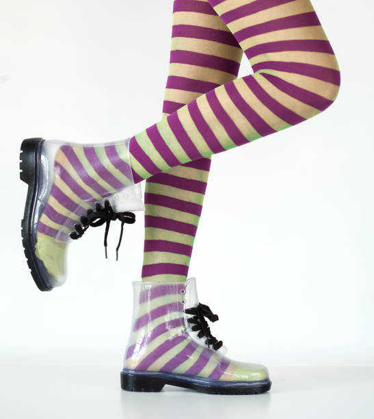 Woman stands with gumboots on white background
