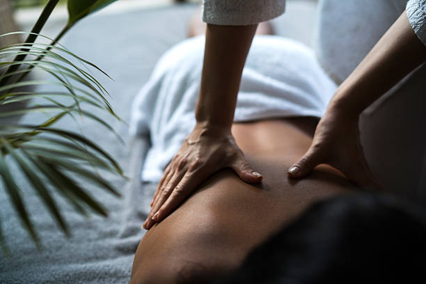 unrecognizable woman receiving back massage at the spa. - massaging massage therapist rear view human hand imagens e fotografias de stock