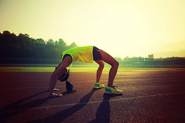 istock young asian woman backbending on stadium track 638876940