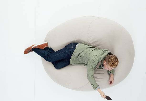 istock Above view of lying on bean bag and using phone 638877796