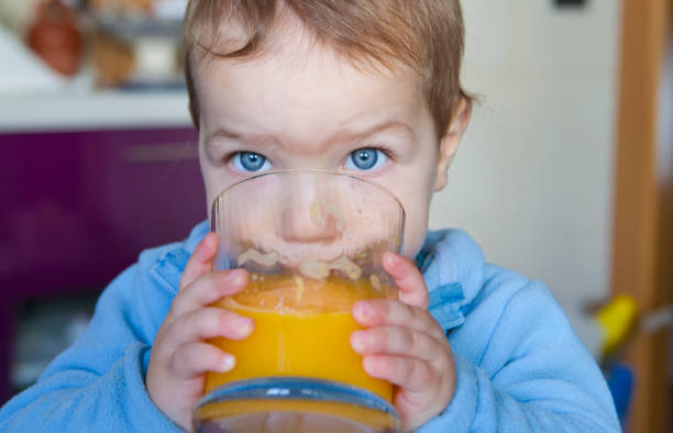 istock Baby boy drinking orange fresh juice 638878082