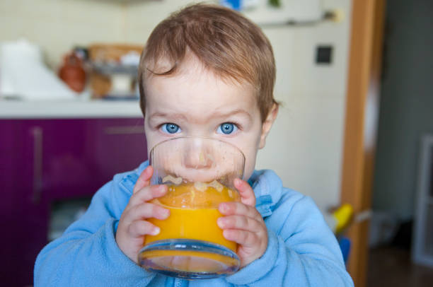 istock Baby boy drinking orange fresh juice 638879340