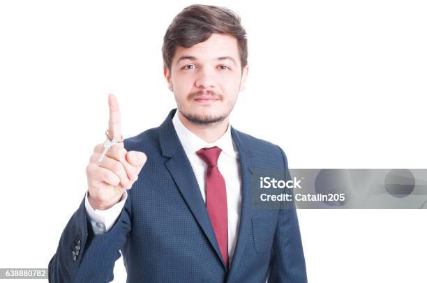 Real Estate Agent Wearing Suit Holding Key And Rolling It Stock Photo - Download Image Now