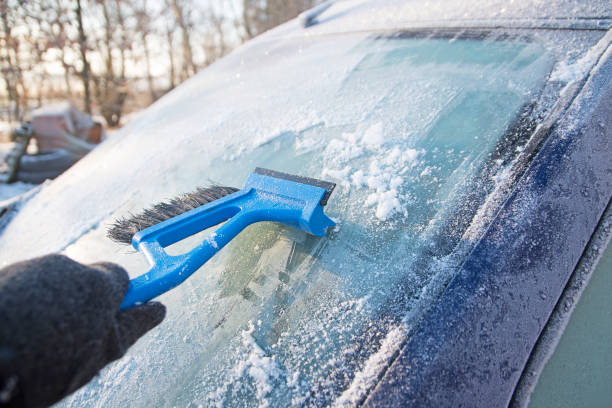 istock Frozen windshield from a car and hand scraping the ice 638880796