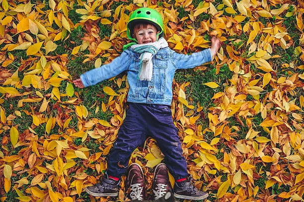 Little boy is enjoying autumn day while pausing his bike ride and posing for the photo