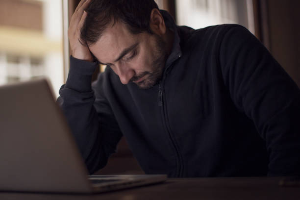 istock Tired man working online at home 638881188