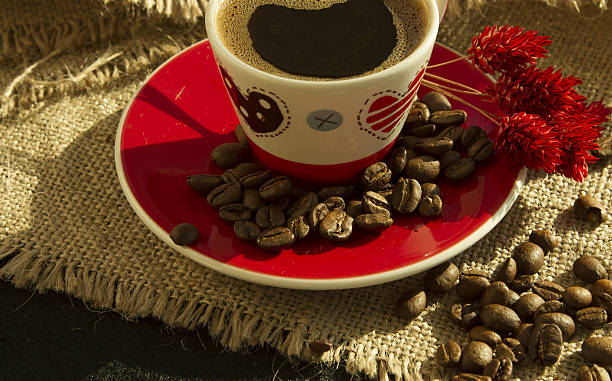 istock Red cup of coffee with coffee beans and flower on 638881448