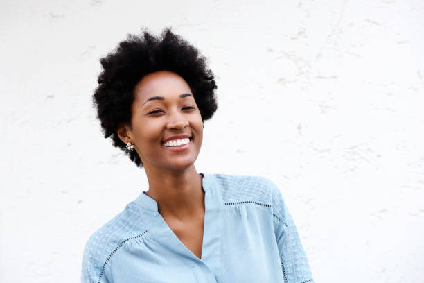 istock Happy young african woman standing against white wall 638881722