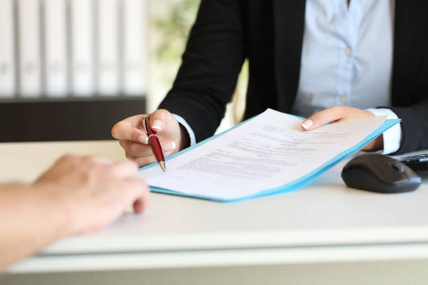 Executive hands indicating where to sign contract Close up of an executive hands holding a pen and indicating where to sign a contract at office legal document stock pictures, royalty-free photos & images