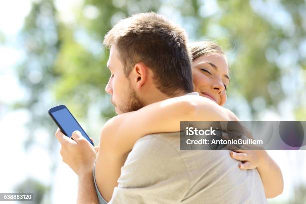 Cheater Hugging His Innocent Girlfriend Stock Photo - Download Image Now - Infidelity, Dishonesty, Men