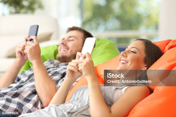 Paar Mit Ihren Smartphones Stockfoto und mehr Bilder von Ausrüstung und Geräte - Ausrüstung und Geräte, Bett, Brand Name Video Game