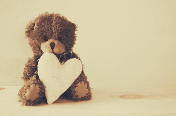istock Cute teddy bear sitting and holding a heart 638883626