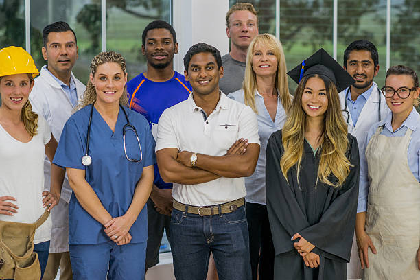 Group of Various Professionals A multi-ethnic group of various working professionals are standing together in a group and are smiling while looking at the camera. various occupations stock pictures, royalty-free photos & images