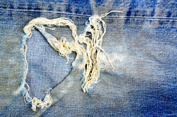 istock Torn and shabby old blue jeans background 638885310