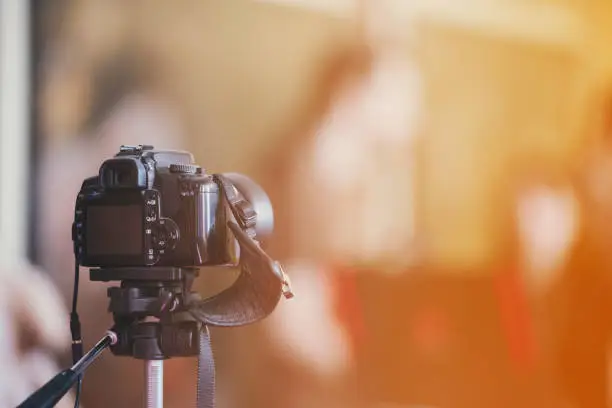 Photo of camera on a tripod indoor with beautiful blured background