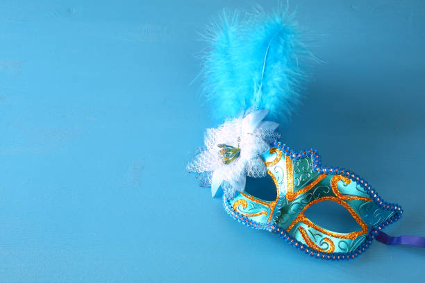 istock elegant venetian mask on blue wooden background 638886032