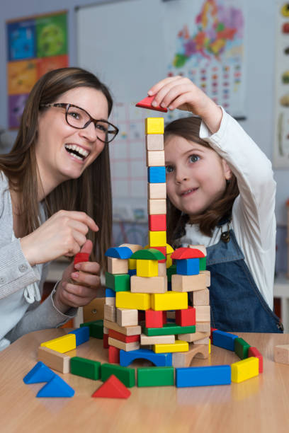 mother and daughter playing together with colorful building toy blocks - block child play toy imagens e fotografias de stock