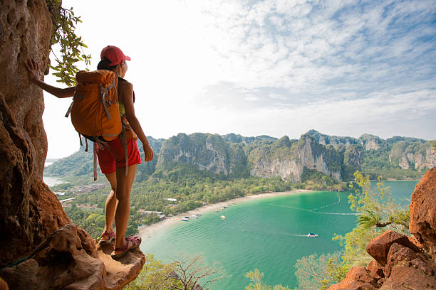 young woman backpacker hiking on seaside mountain