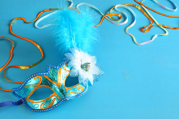istock elegant venetian mask on blue wooden background 638886428