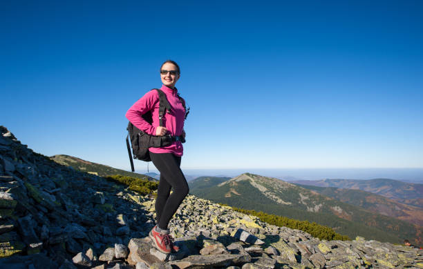 istock Woman backpacker on rocky mountain peak 638886462