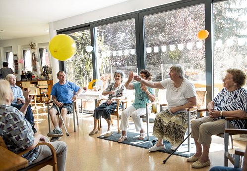 Personas mayores que participan en actividades grupales en la guardería para adultos photo