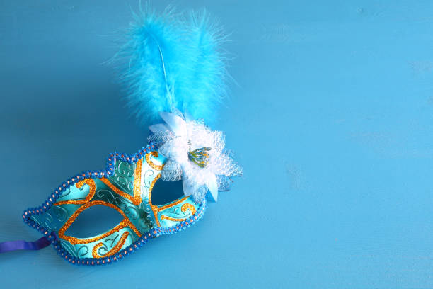 istock elegant venetian mask on blue wooden background 638887572