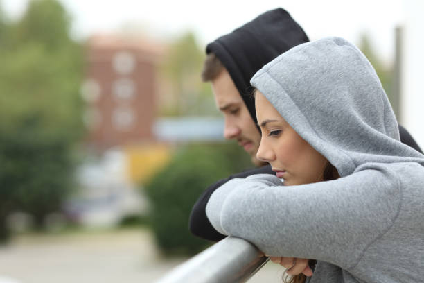 istock Sad couple of teens looking down in a balcony 638890416