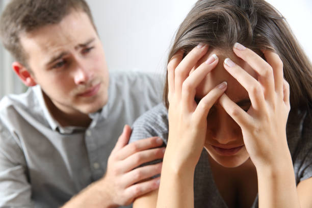 Sad woman and a friend comforting Meeting of a sad woman and a friend or boyfriend trying to comfort her at home woman comforting depressed friend stock pictures, royalty-free photos & images