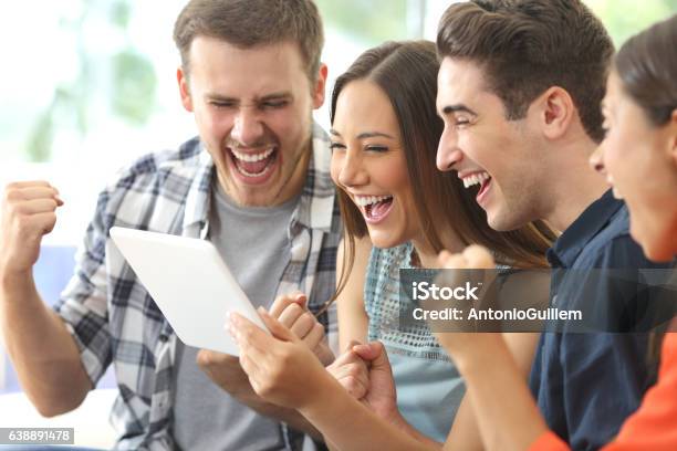 Excited Group Of Friends Watching Tv From Tablet Stock Photo - Download Image Now - Educational Exam, Gambling, Group Of People