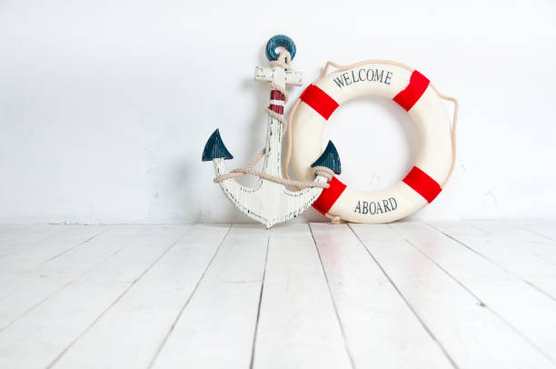 istock Anchor and life buoy on a white wooden floor 638891908