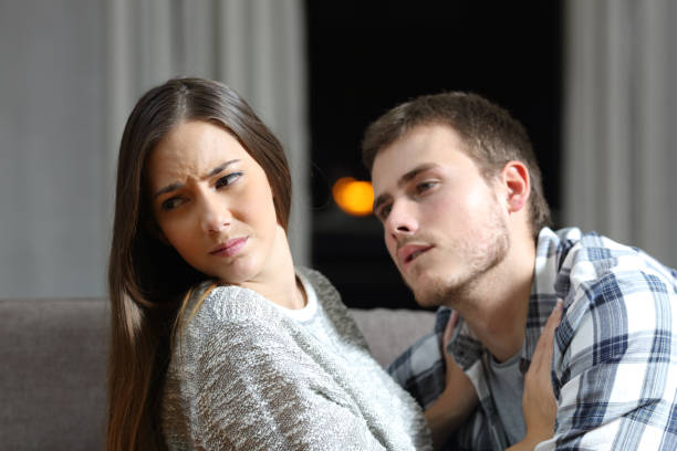 Man trying to force sex and his girlfriend denying Insistent man trying to get sex and his worried girlfriend denying on a couch in the night at home disgust stock pictures, royalty-free photos & images