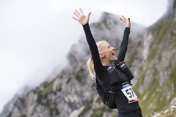 Woman arms raised Hiker mature woman cheering arms raised on mountain. number 58 stock pictures, royalty-free photos & images