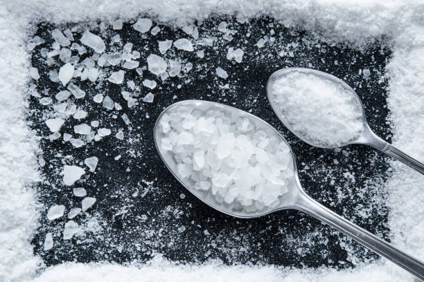 istock Sea salt grains frame on the black background. 638895332