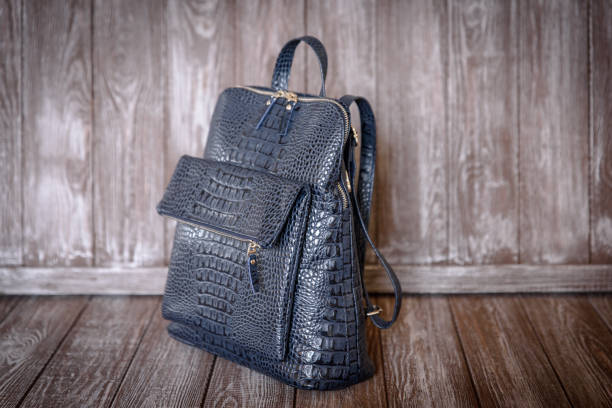 istock blue leather bag on brown wooden background. 638895536