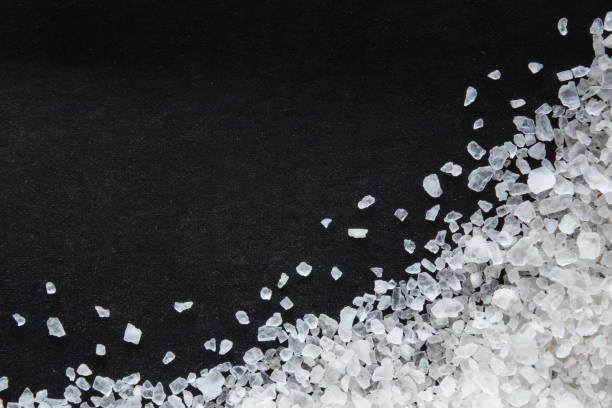 istock Sea salt grains on the black background. 638895702