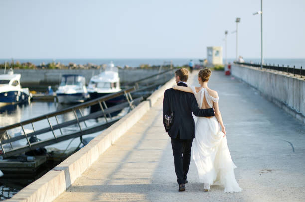 istock Happy bride and groom walking on pier 638895958